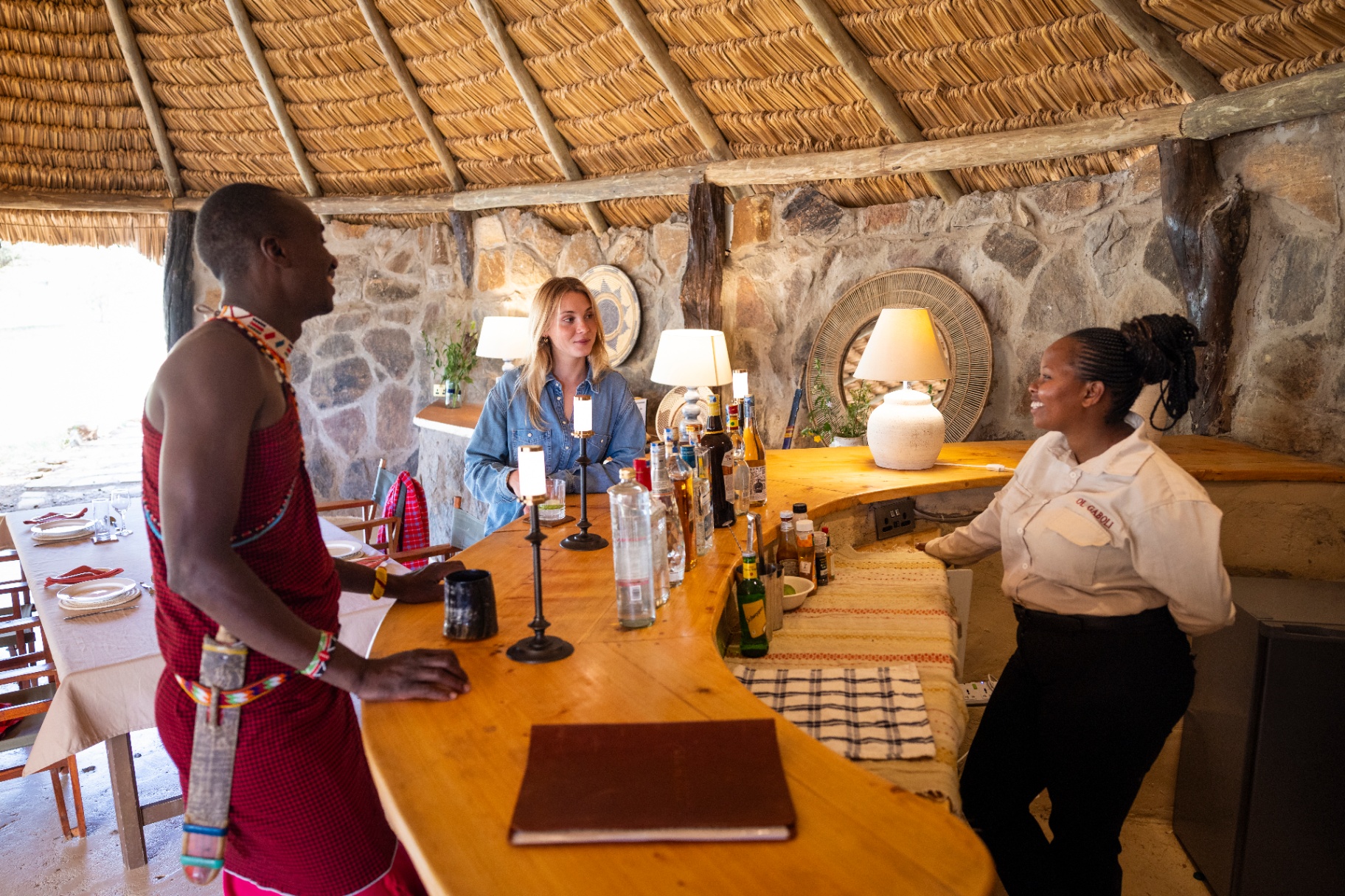 Guide and bartender speaking with a guest at the lodge bar